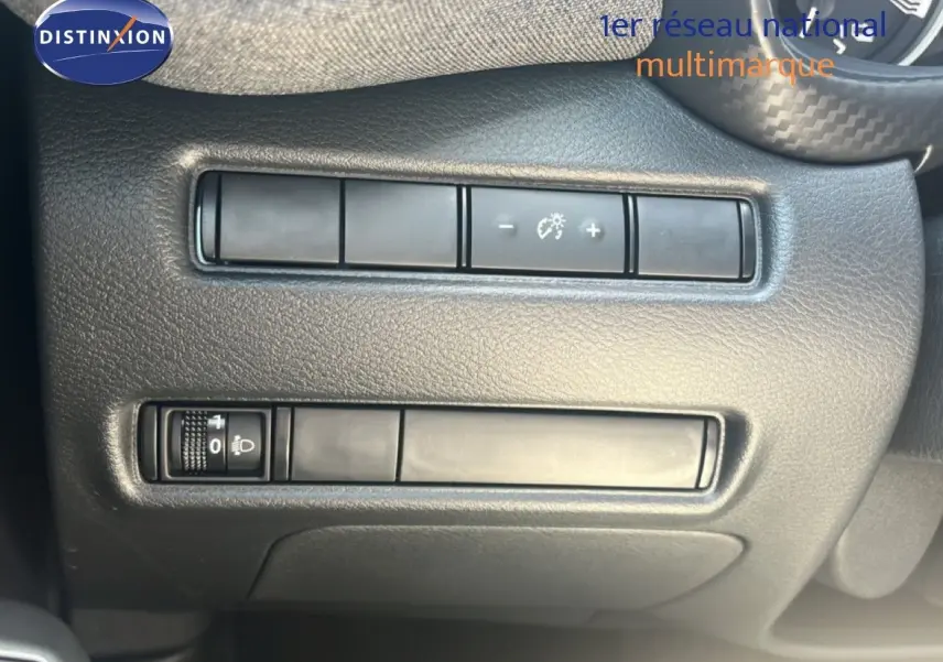 Détail des commandes d’éclairage et réglages du tableau de bord sur Nissan Juke Hybrid gris, intérieur noir.