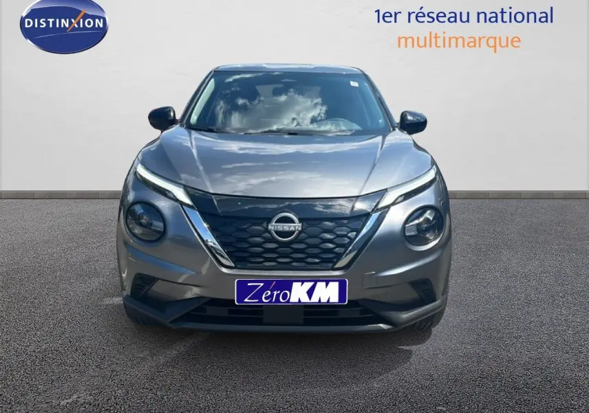Vue frontale du Nissan Juke hybride gris squale métal avec calandre noire et phares ronds distinctifs.