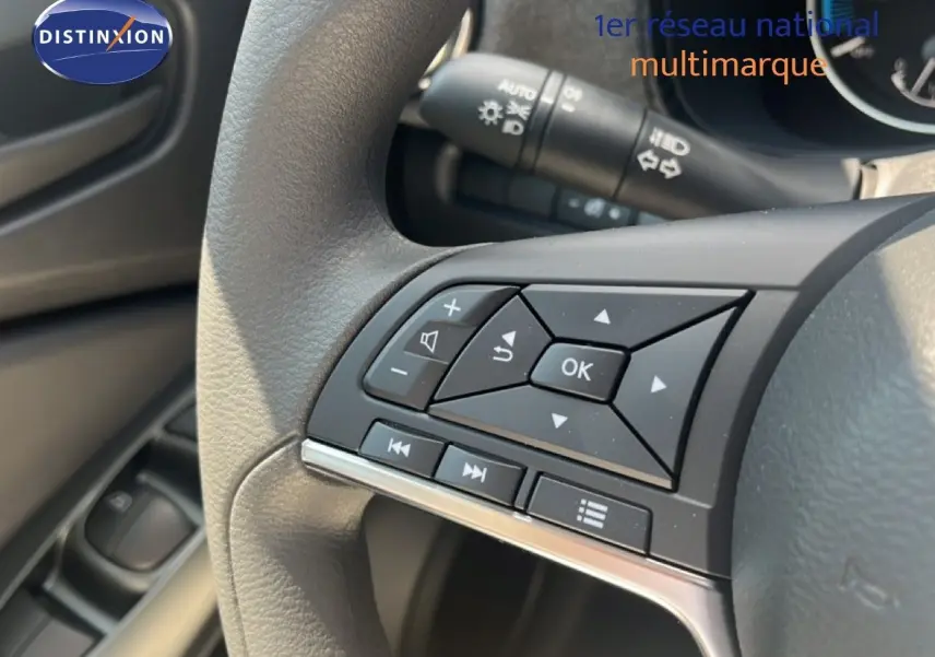 Gros plan sur les commandes au volant du Nissan Juke gris squale métal, mettant en valeur les boutons multifonctions.