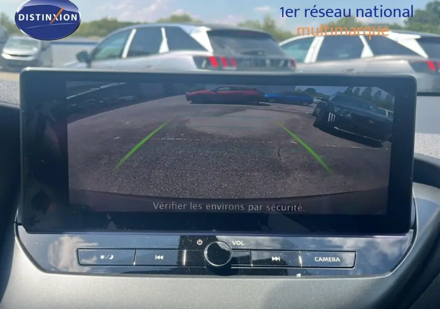 Écran central montrant la caméra de recul d’un Nissan Juke Hybrid gris, vue intérieure du tableau de bord.