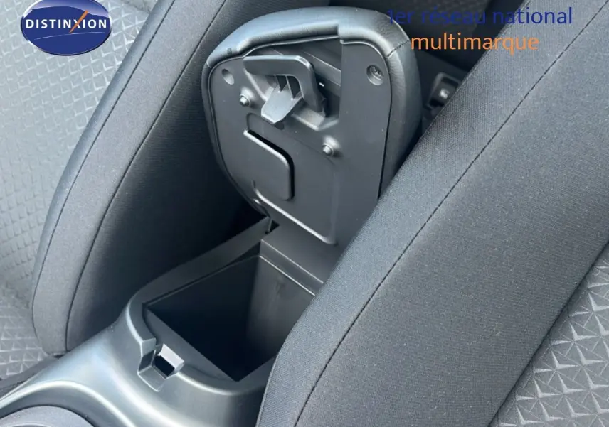 Vue rapprochée de la console centrale ouverte entre les sièges avant du Nissan Juke gris Squale Metal 2025.