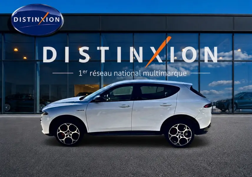 Vue de profil droit d'un Alfa Romeo Tonale blanc 2025 devant une vitrine Distinxion, avec jantes alu distinctives.