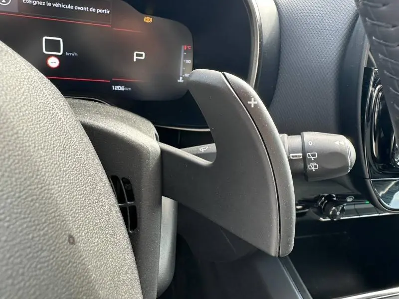 Gros plan sur la palette de changement de vitesse droite du Citroën C5 Aircross noir, avec tableau de bord numérique en arrière-plan.