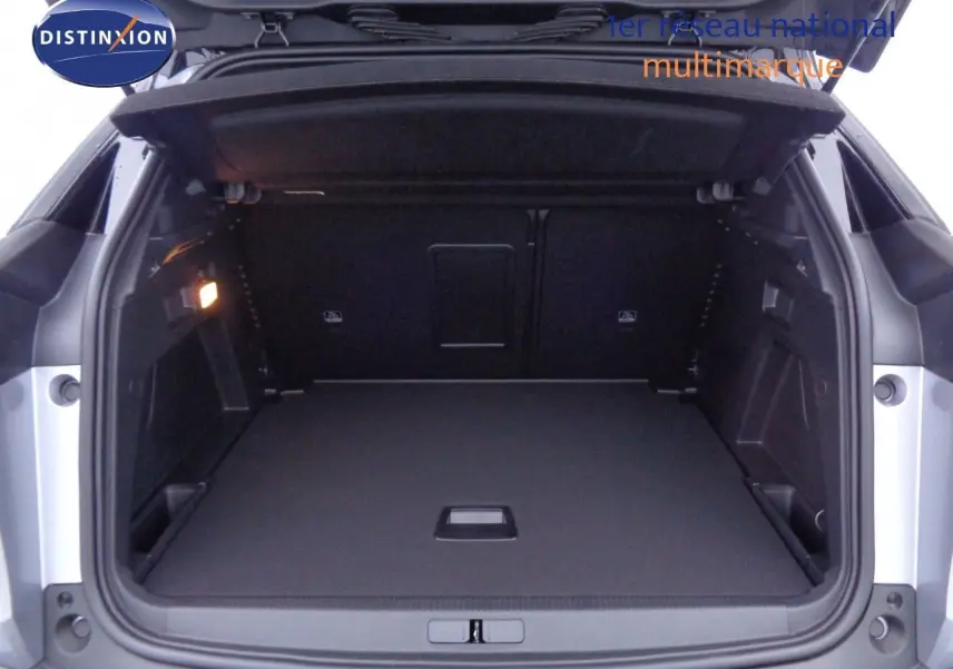 Coffre ouvert d'un Peugeot 3008 gris Artense métal, vue arrière montrant un espace de chargement spacieux et bien éclairé.
