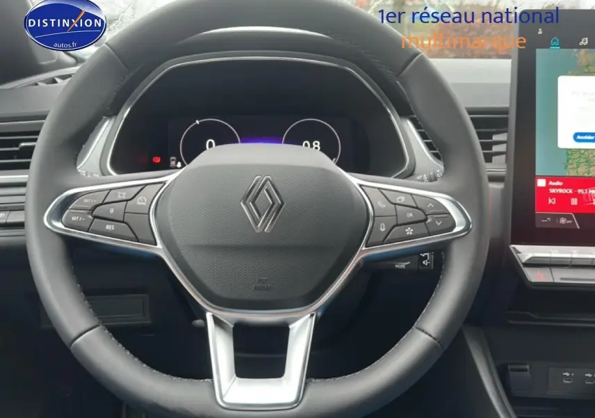 Vue rapprochée du volant multifonction noir du Renault Captur 2025 avec tableau de bord numérique et écran tactile visible à droite.