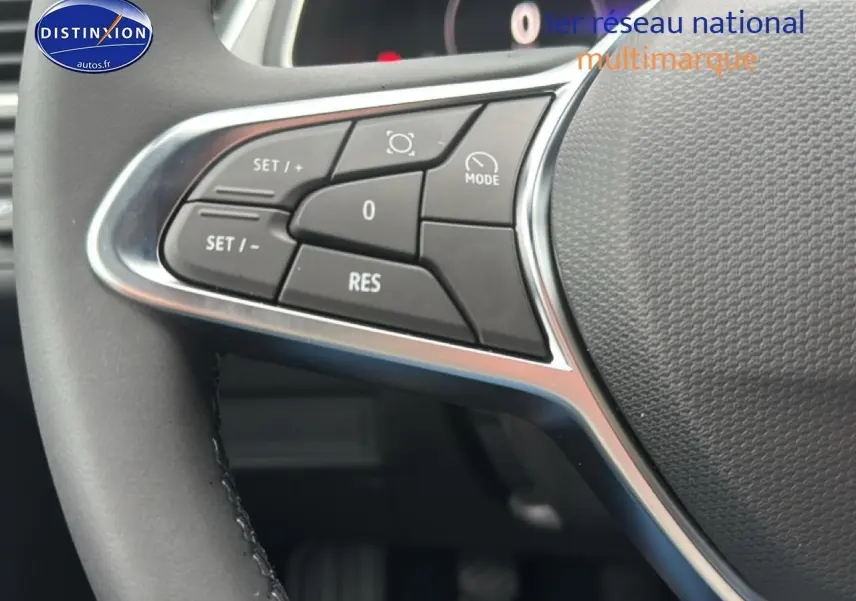 Gros plan sur les commandes multifonctions à gauche du volant du Renault Captur gris cassiopée, intérieur moderne.