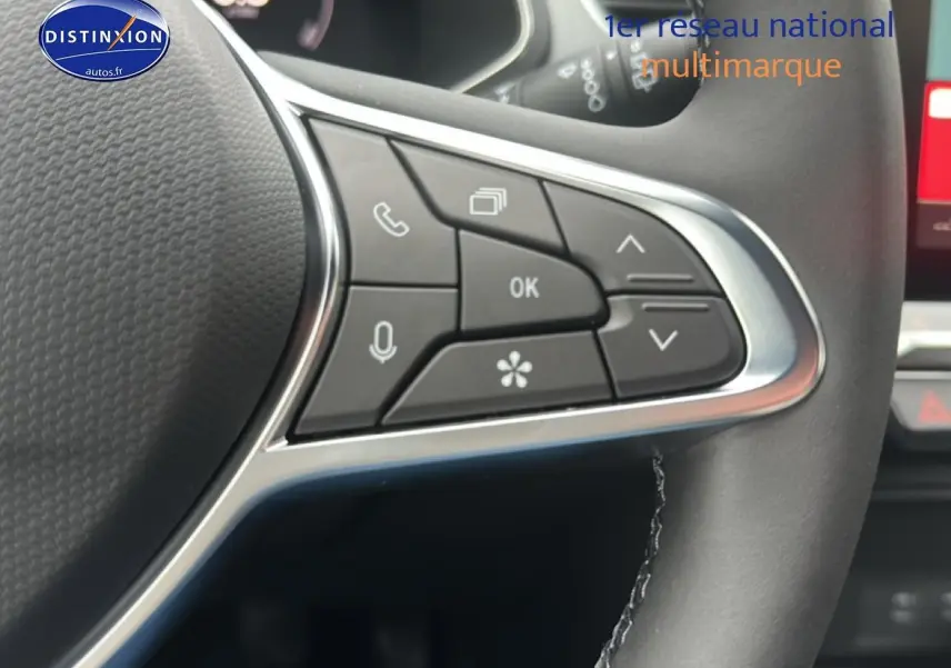 Gros plan sur les commandes multifonctions noires du volant du Renault Captur gris cassiopée, intérieur moderne.
