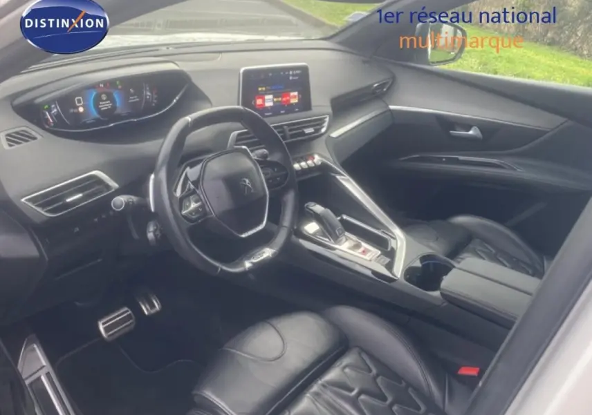 Vue intérieure côté conducteur du Peugeot 3008 blanc, mettant en valeur le volant cuir et l'écran tactile central.