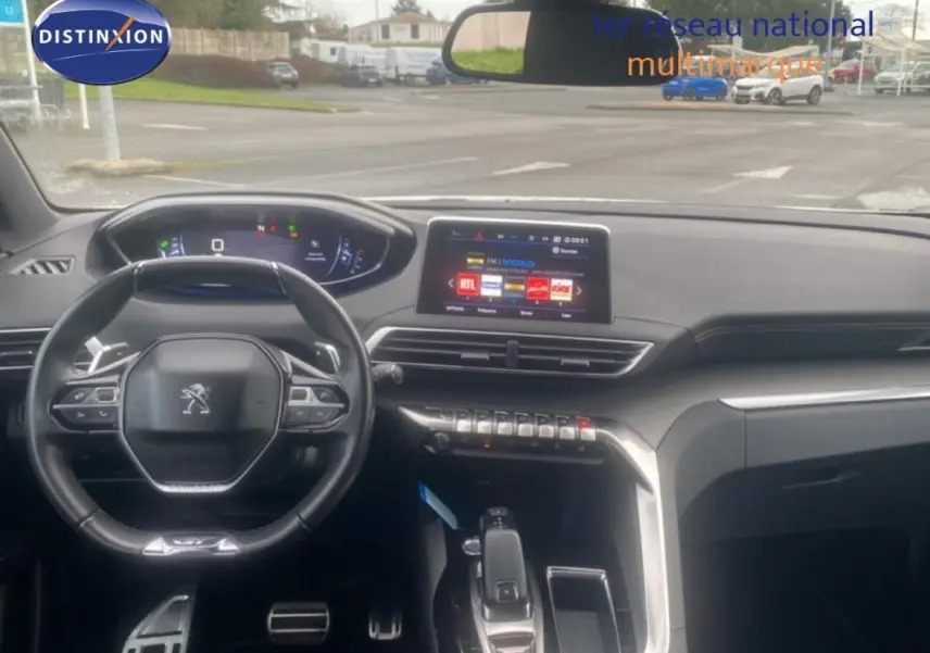 Vue intérieure du poste de conduite du Peugeot 3008 blanc de 2018, avec volant cuir et écran tactile central.