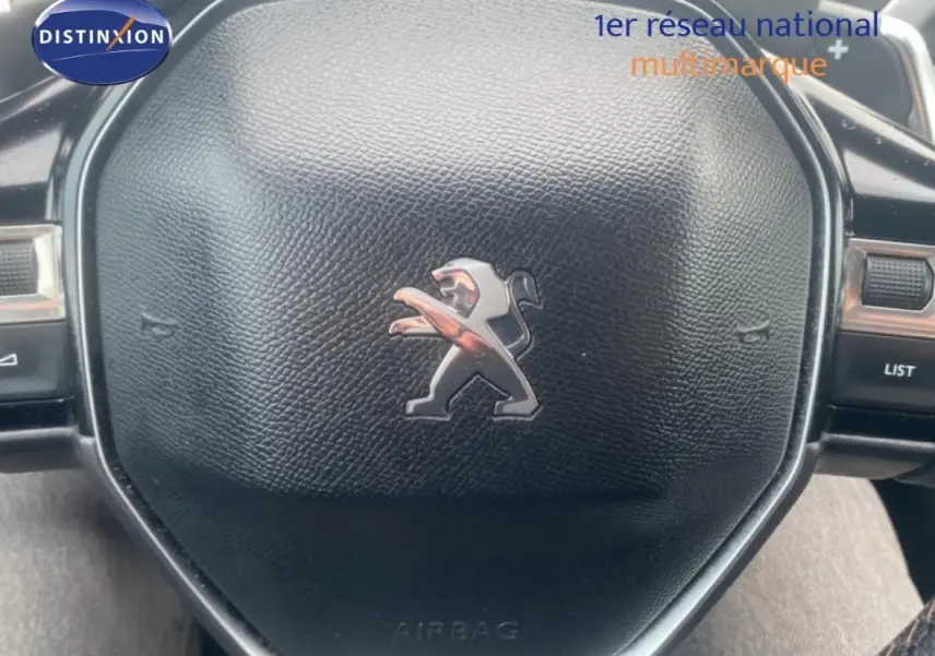 Gros plan sur le volant cuir noir avec logo Peugeot du SUV 3008 blanc, version GT de 2018.