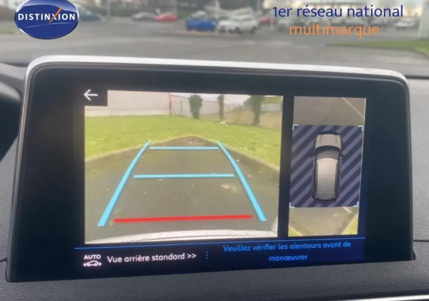 Écran tactile intérieur montrant la caméra de recul et l'aide au stationnement du Peugeot 3008 blanc.