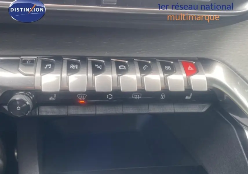 Gros plan sur la rangée de boutons de commande argentés du tableau de bord du Peugeot 3008 blanc, version GT.