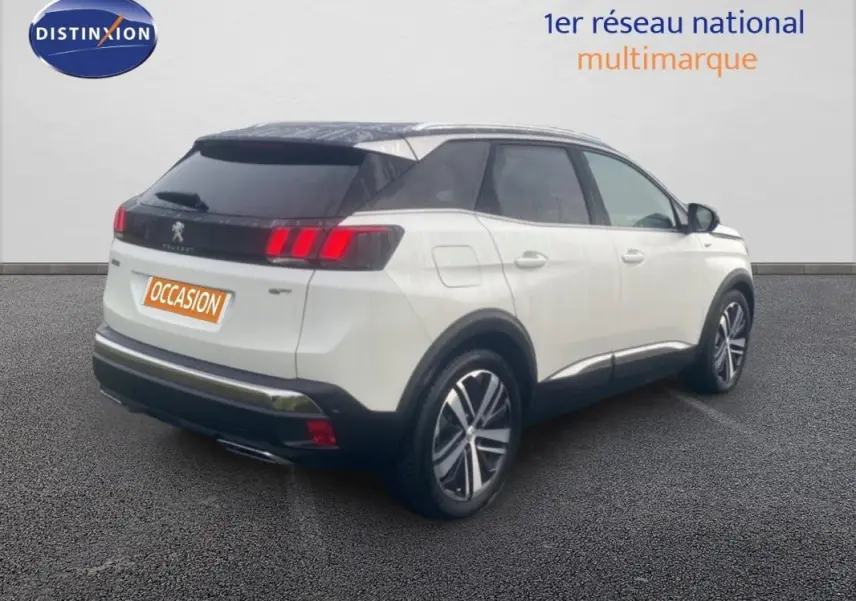 Vue 3/4 arrière droite d’un Peugeot 3008 blanc avec toit noir, jantes alliage 19 pouces et barres de toit.