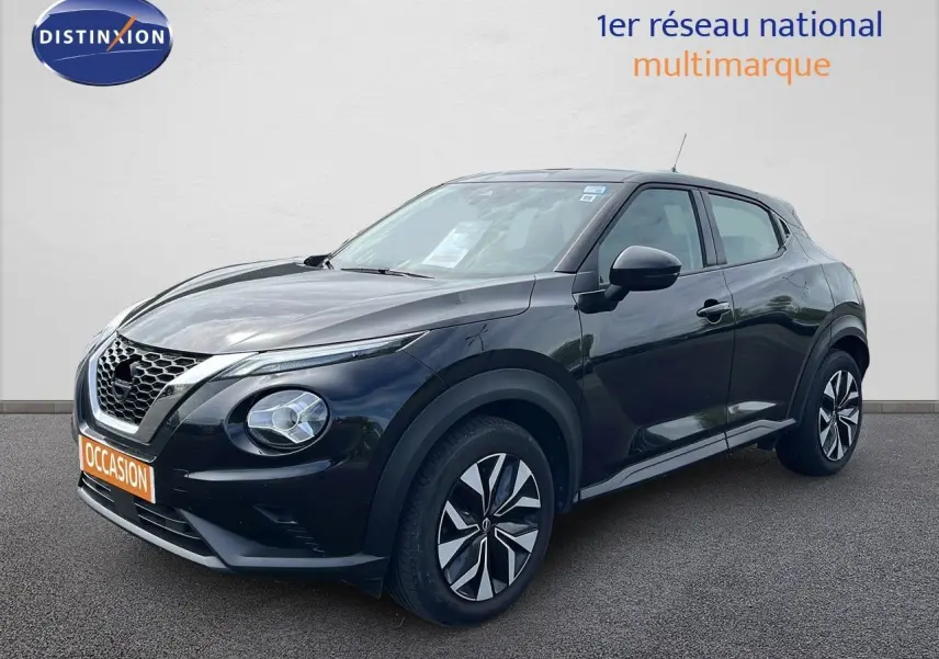 Nissan Juke noir métal en 3/4 avant droit, avec jantes distinctives et calandre en V caractéristique.