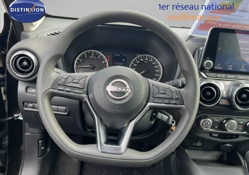 Vue intérieure centrée sur le volant Nissan du Juke 2023, avec tableau de bord et écran tactile visibles.