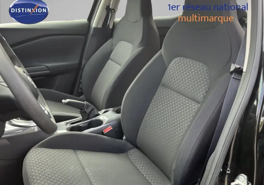 Vue intérieure rapprochée des sièges avant en tissu gris et noir du Nissan Juke 2023 noir métal.