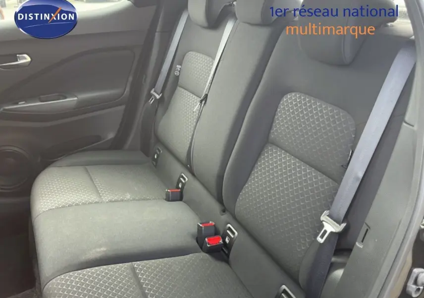 Vue latérale du siège arrière noir tissu du Nissan Juke 2023, mettant en valeur les ceintures de sécurité et les textures du revêtement.