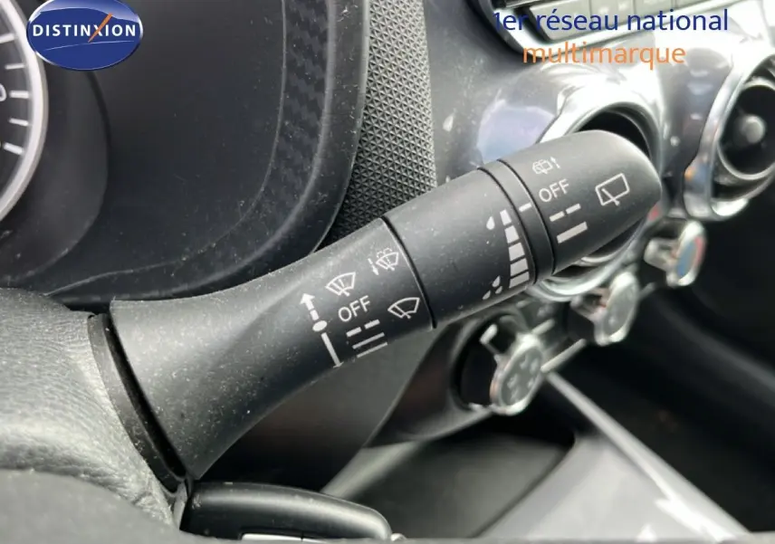 Gros plan sur la commande d’essuie-glace noire dans l’habitacle du Nissan Juke 2023, avec tableau de bord partiellement visible.