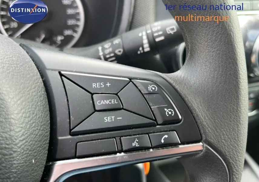 Gros plan sur les commandes au volant du Nissan Juke 2023 noir métal, mettant en valeur les boutons de régulateur de vitesse.