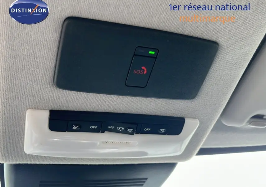 Vue en gros plan du plafonnier intérieur avec bouton SOS allumé sur Nissan Juke noir métal 2023.