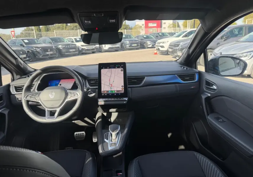 Vue intérieure avant du Renault SYMBIOZ gris clair 2025, avec tableau de bord moderne et écran tactile vertical.