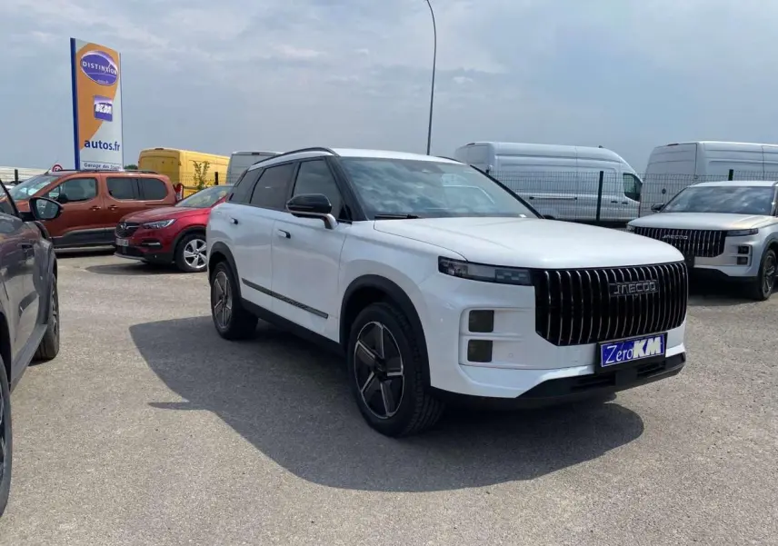 SUV JAECOO J7 blanc khaki vu en 3/4 avant droit avec calandre verticale noire et jantes alliage 19 pouces.