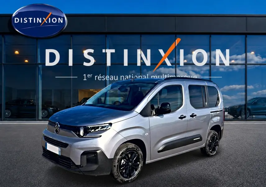 Citroën Berlingo Steel Grey vue 3/4 avant droit, avec jantes noires et barres de toit visibles.