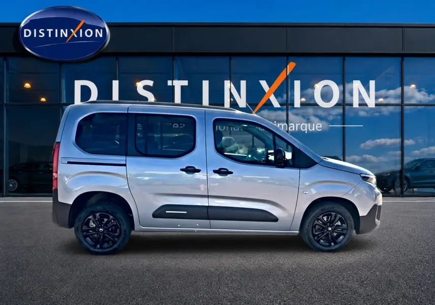 Profil droit d'un Citroën Berlingo 2026 gris acier avec barres de toit et jantes alliage noires.