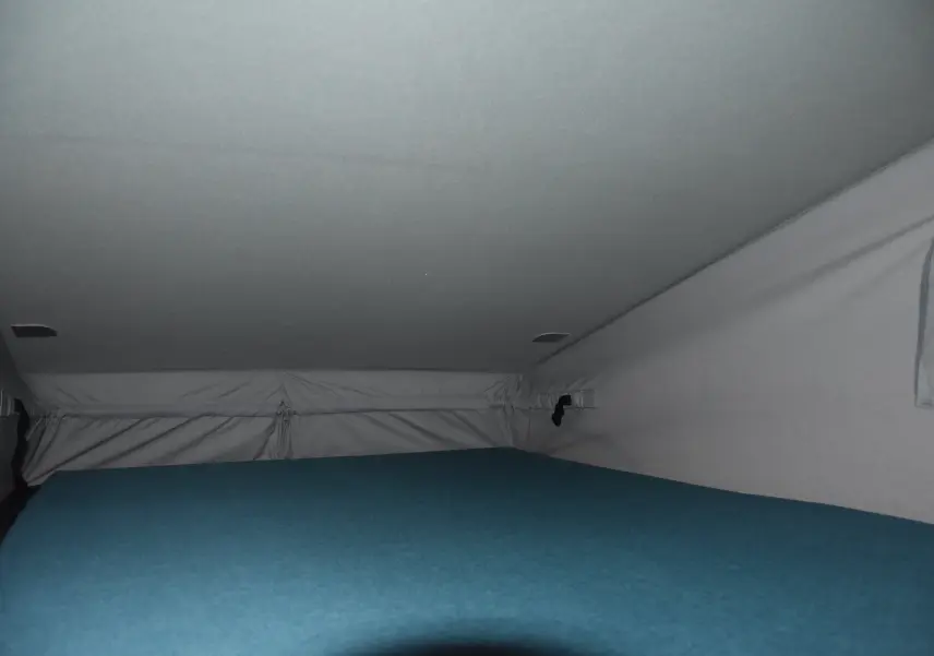 Vue intérieure du toit relevable avec couchage bleu dans un Renault Trafic Combi blanc 2021