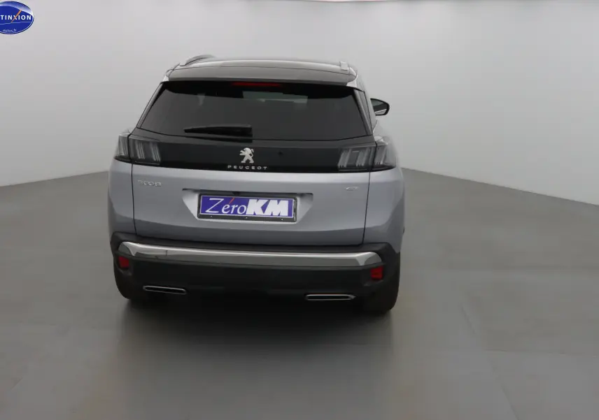 Vue arrière du Peugeot 3008 GT gris Artense métal 2023 avec feux arrière noirs et double sortie d'échappement intégrée.