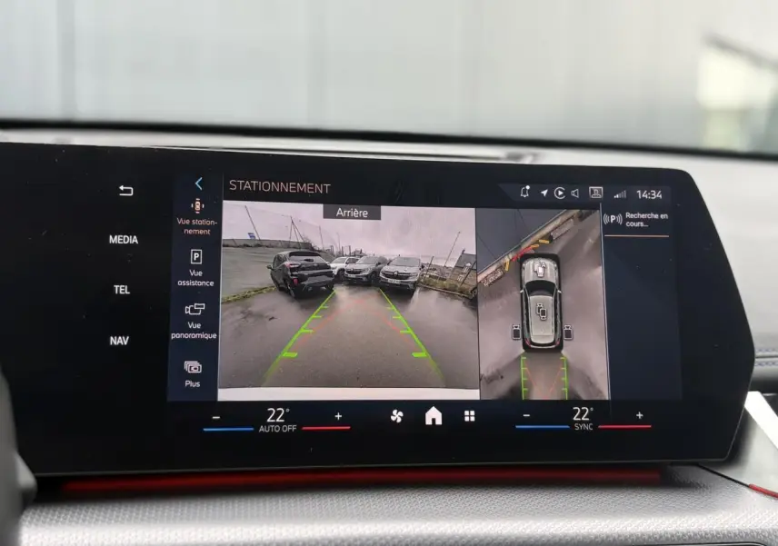 Affichage écran intérieur du BMW X1 blanc Mineral montrant la caméra de recul et vue 360° en stationnement.