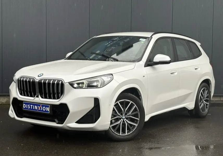 BMW X1 sDrive 20d blanc Mineral vue 3/4 avant, calandre imposante et jantes alliage bicolores visibles