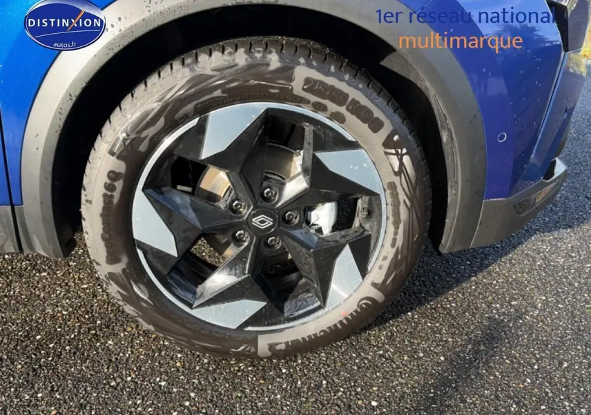 Gros plan sur la roue avant droite d’un Renault Captur 2025 Bleu Iron avec jante alu bicolore design.