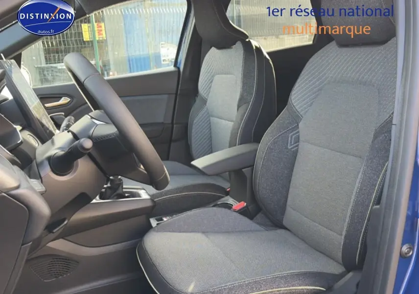 Vue intérieure côté conducteur du Renault Captur Bleu Iron 2025, sièges tissu gris avec accoudoir central.