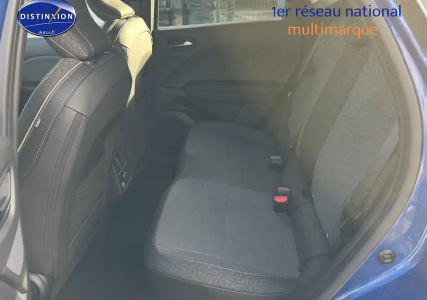 Vue intérieure arrière droite du Renault Captur bleu iron, montrant la banquette tissu et les sièges avant noirs.