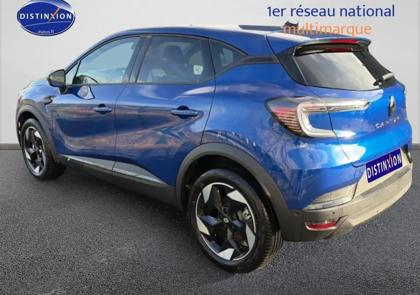 Renault Captur bleu iron vu en 3/4 arrière droit, avec jantes alliage et toit noir contrasté.