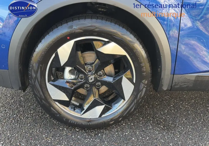 Gros plan sur la roue avant gauche du Renault Captur bleu iron avec jante alu à design étoilé.