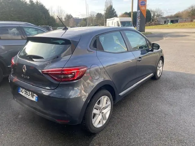 Vue 3/4 arrière droite d'une Renault Clio gris métallisé 2021, compacte à cinq portes avec feux arrière LED distinctifs.