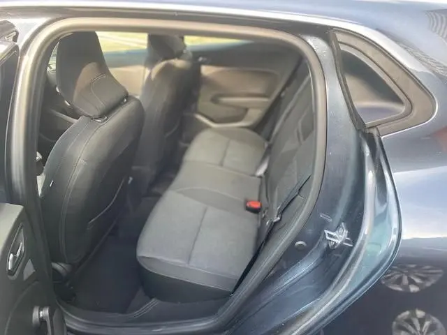 Vue intérieure arrière droite de la Renault Clio gris 2021, montrant les sièges tissu et l'ouverture de la porte arrière.
