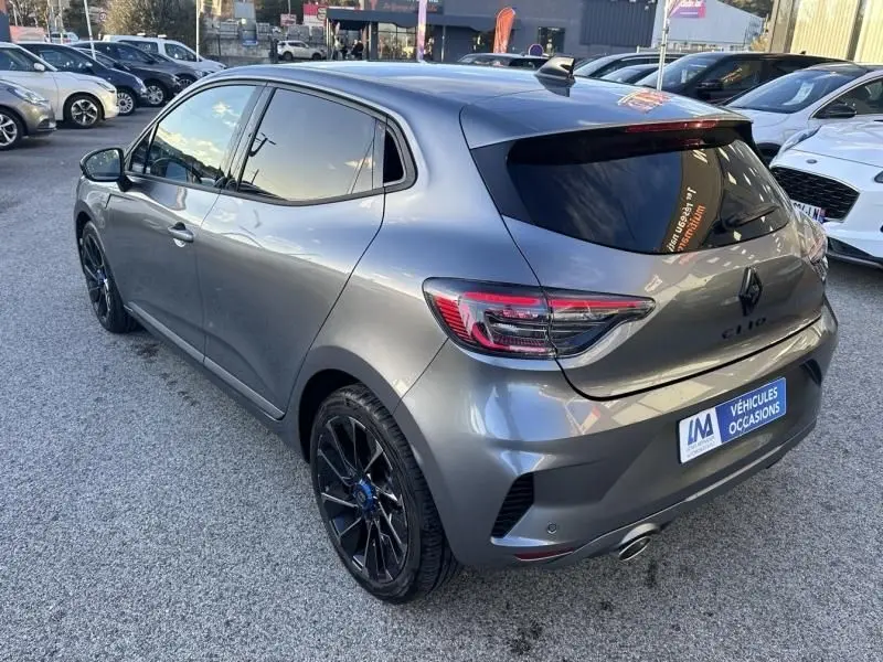 Vue 3/4 arrière droite d'une Renault Clio V gris schiste avec jantes noires et vitres teintées, version Esprit Alpine 2025.