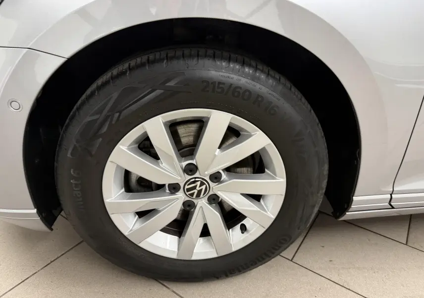 Gros plan sur la roue avant gauche de la Volkswagen Passat SW 2024 gris pyrite avec jante alliage et logo VW central.