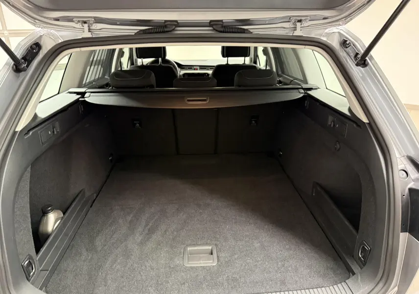 Vue arrière du coffre spacieux et propre d'une Volkswagen Passat SW 2.0 TDI 122 DSG7 Business gris pyrite 2024.