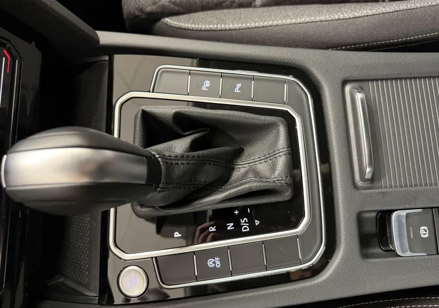 Gros plan sur la console centrale de la Volkswagen Passat SW 2024 avec levier de vitesse automatique et bouton start/stop.