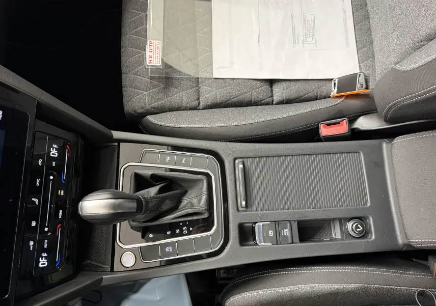 Vue rapprochée de la console centrale de la Volkswagen Passat SW 2.0 TDI 122 DSG7 Business avec levier de vitesse et bouton start/stop.