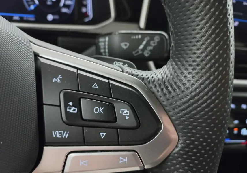 Gros plan sur les commandes au volant en cuir perforé du Volkswagen T-Roc 1.5 TSI 2025, finition R-Line.