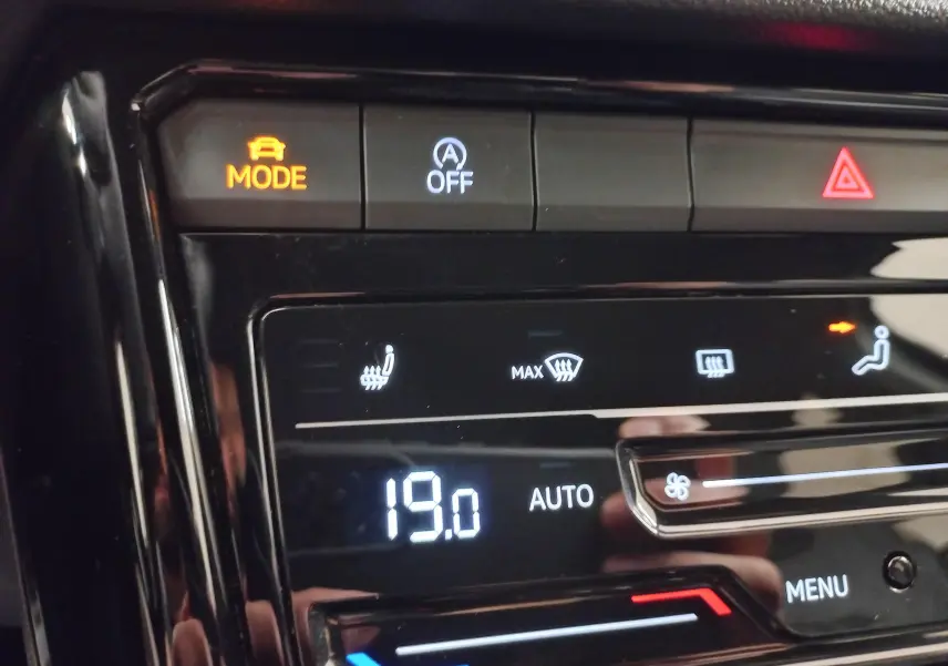 Tableau de bord du Volkswagen T-Roc 2025 en gros plan, avec commandes de climatisation et sièges chauffants visibles.
