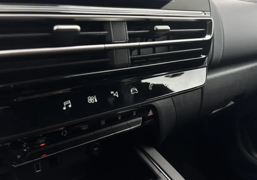 Gros plan sur la console centrale noire brillante du Citroën C5 Aircross 2025, avec aérateurs et commandes tactiles.