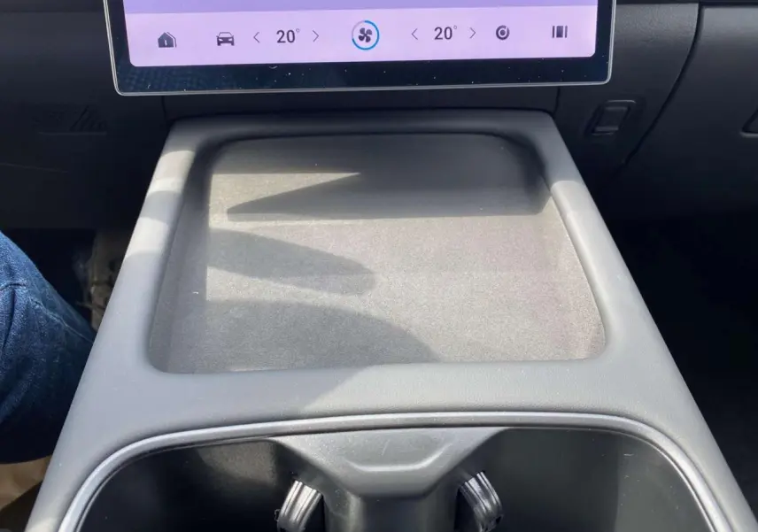 Vue rapprochée de la console centrale grise du JAECOO J7 1.5 SHS-P, avec écran tactile et porte-gobelets visibles.