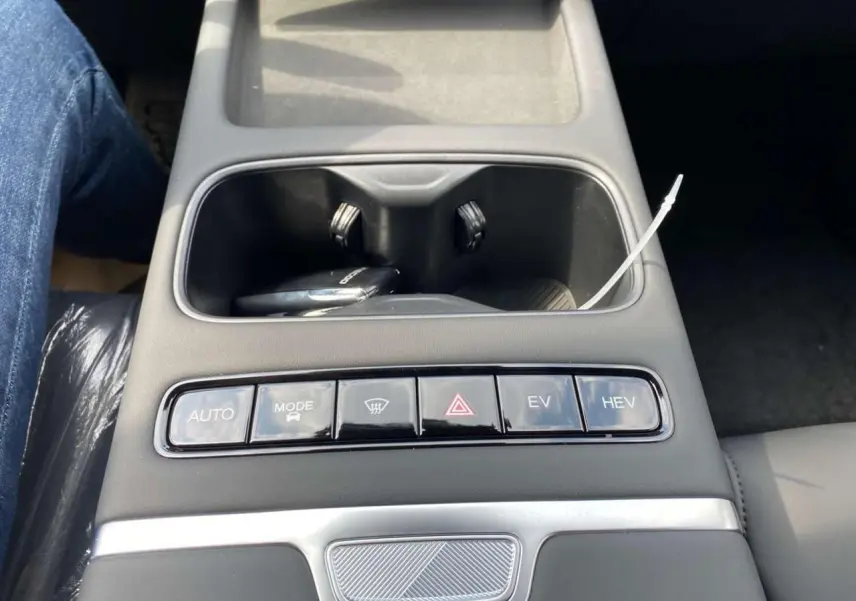 Gros plan sur la console centrale noire du JAECOO J7 argent Moonlight, avec rangements et boutons de modes de conduite.
