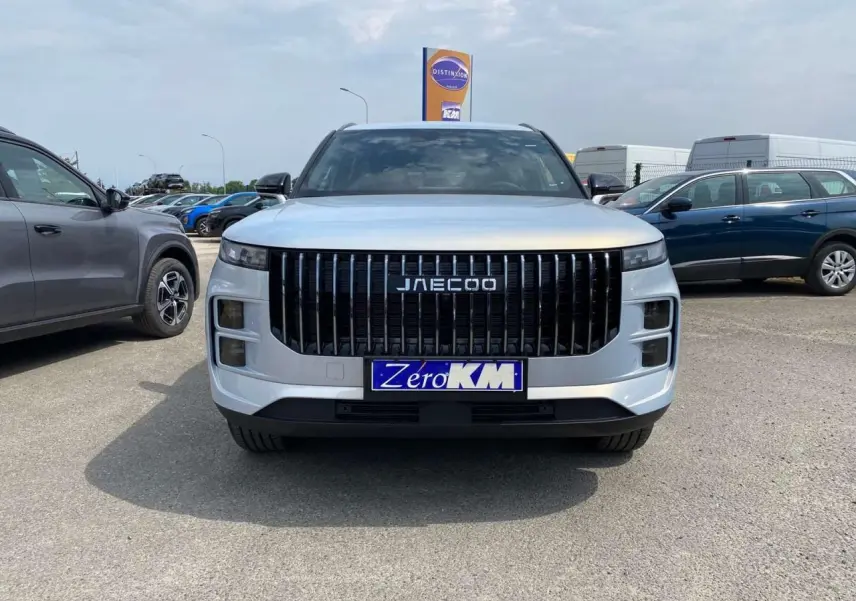 Vue frontale d'un JAECOO J7 1.5 SHS-P argent Moonlight avec calandre verticale noire et plaque Zero KM.